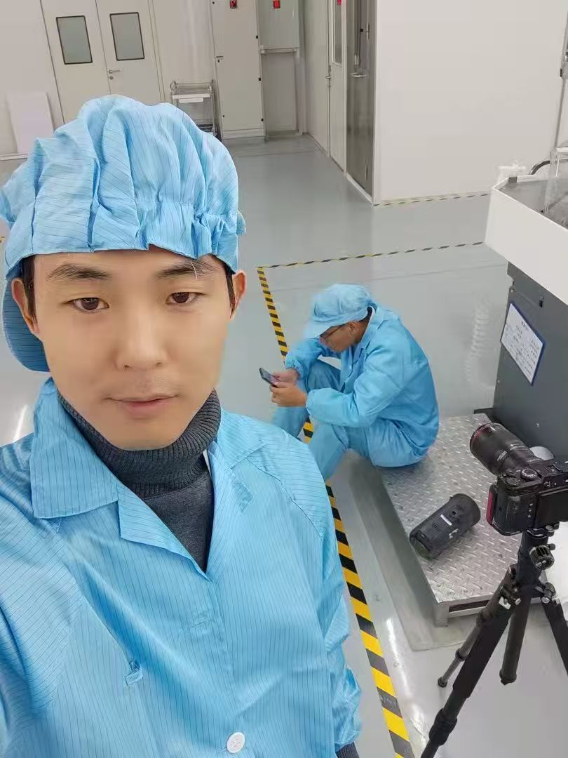 徐飞与灯光助理在洁净生产区执行拍摄